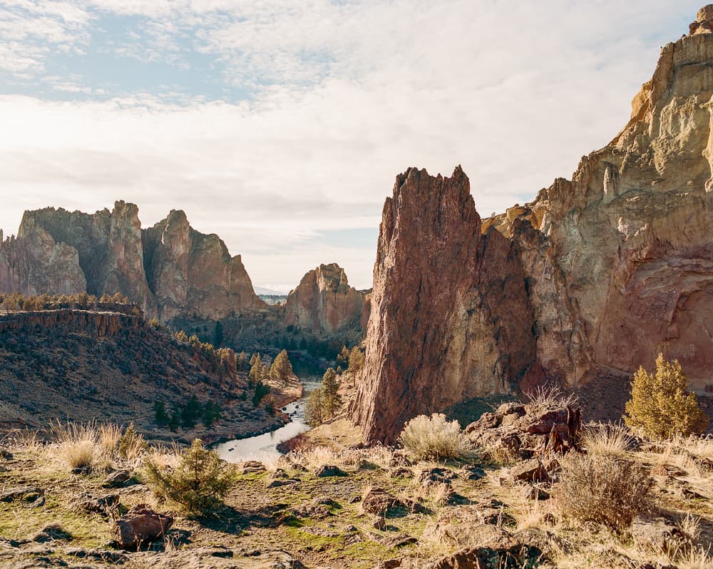 Craggy rock spires of Smith Rock rising above the river canyon in golden light